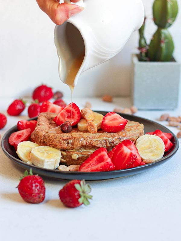 Whole wheat French toast with banana, strawberries, honey and hazelnuts